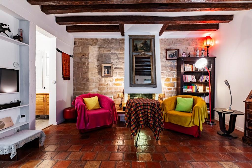 - un salon avec deux chaises et un mur en pierre dans l'établissement Veeve - Rustic Allure, à Paris