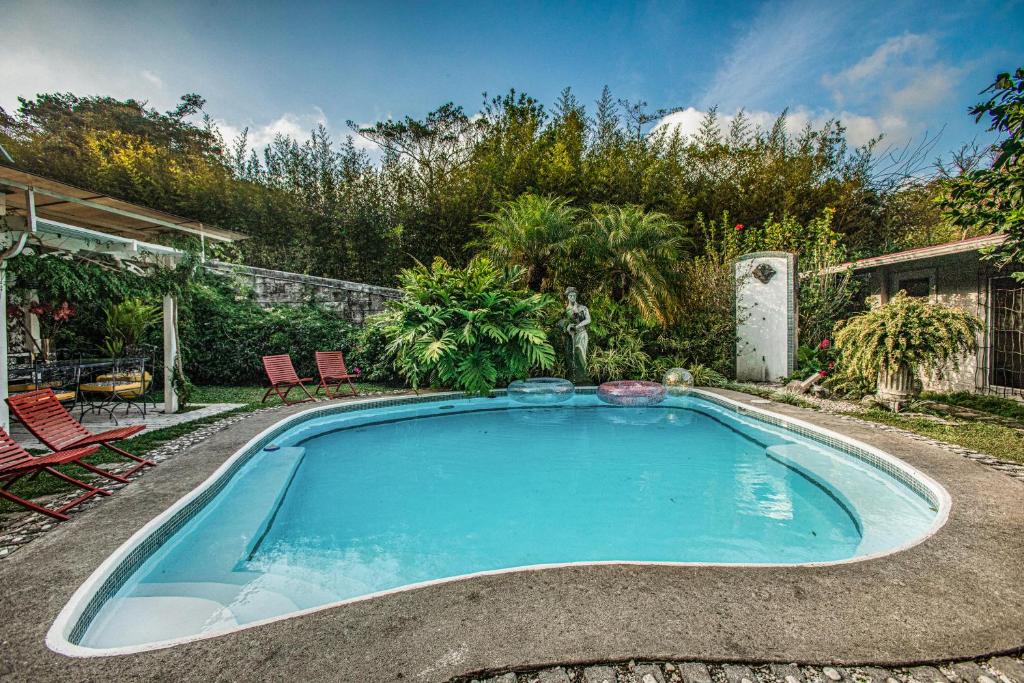 einen Pool im Garten mit Stühlen und Bäumen in der Unterkunft Casa Madre Tierra in El Valle de Antón