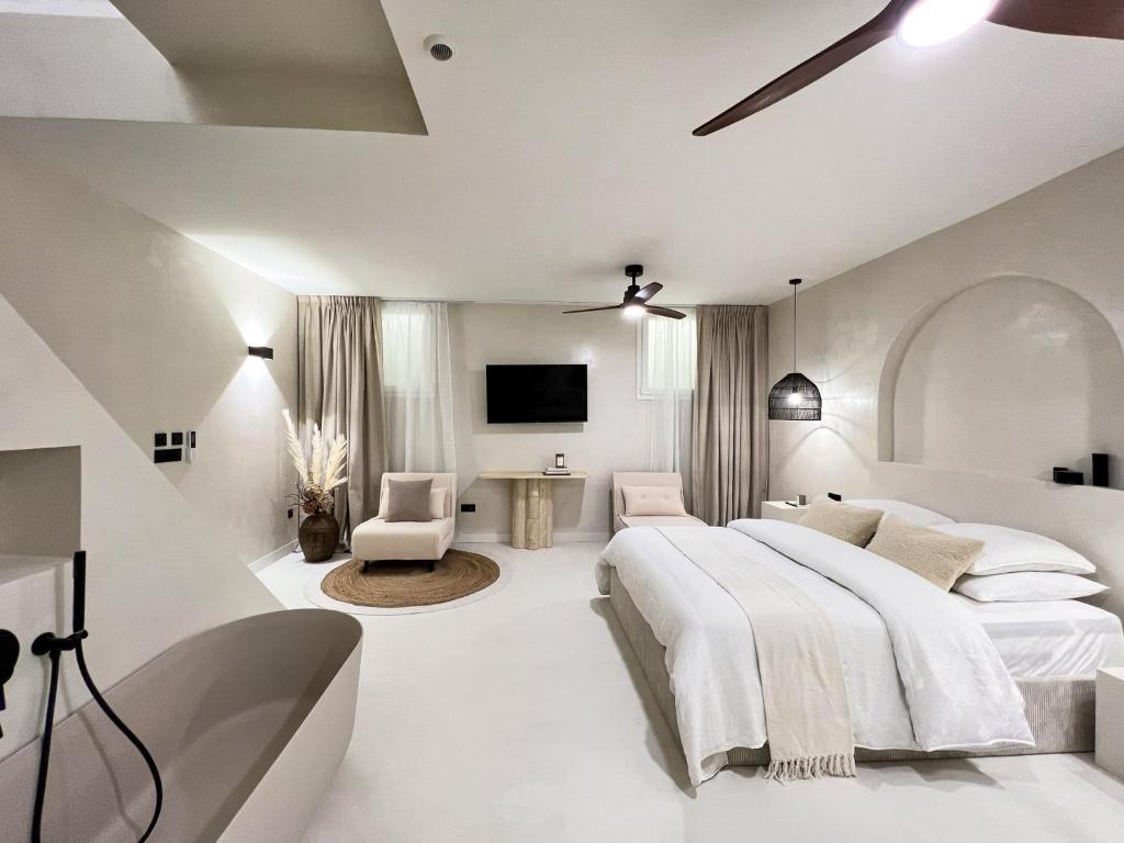 a white bedroom with a large bed and a tv at Superb Apartment Palais Royal Louvre Museum in Paris