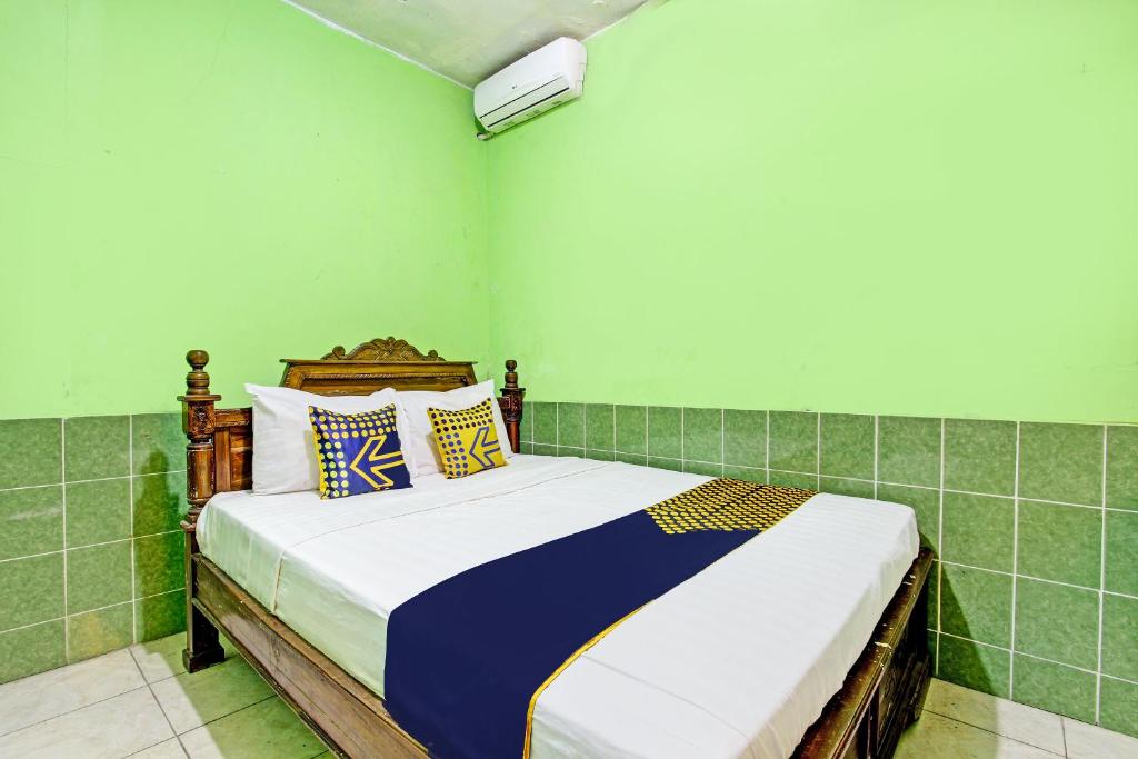 um quarto com uma cama grande num quarto em SPOT ON 93029 Pondok Wisata Sabar Menanti 2 em Bantul