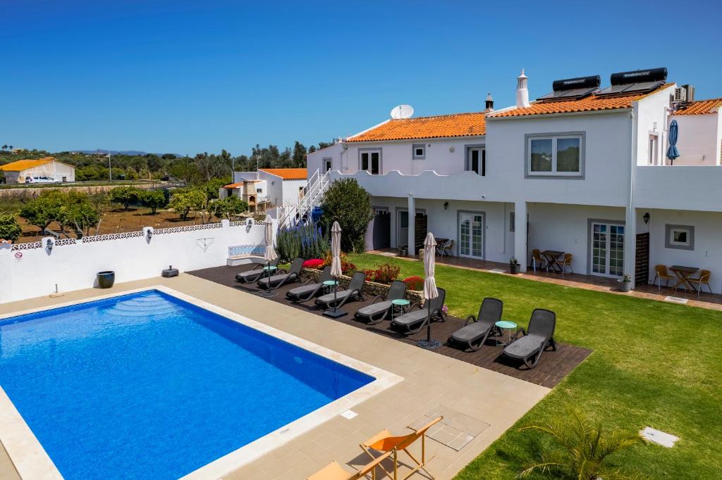 een villa met een zwembad en een huis bij Casa Jardim Oasis in Lagoa