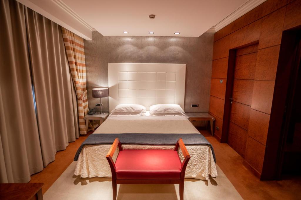 a bedroom with a bed and a red chair at Papillo Hotels & Resorts Roma in Rome