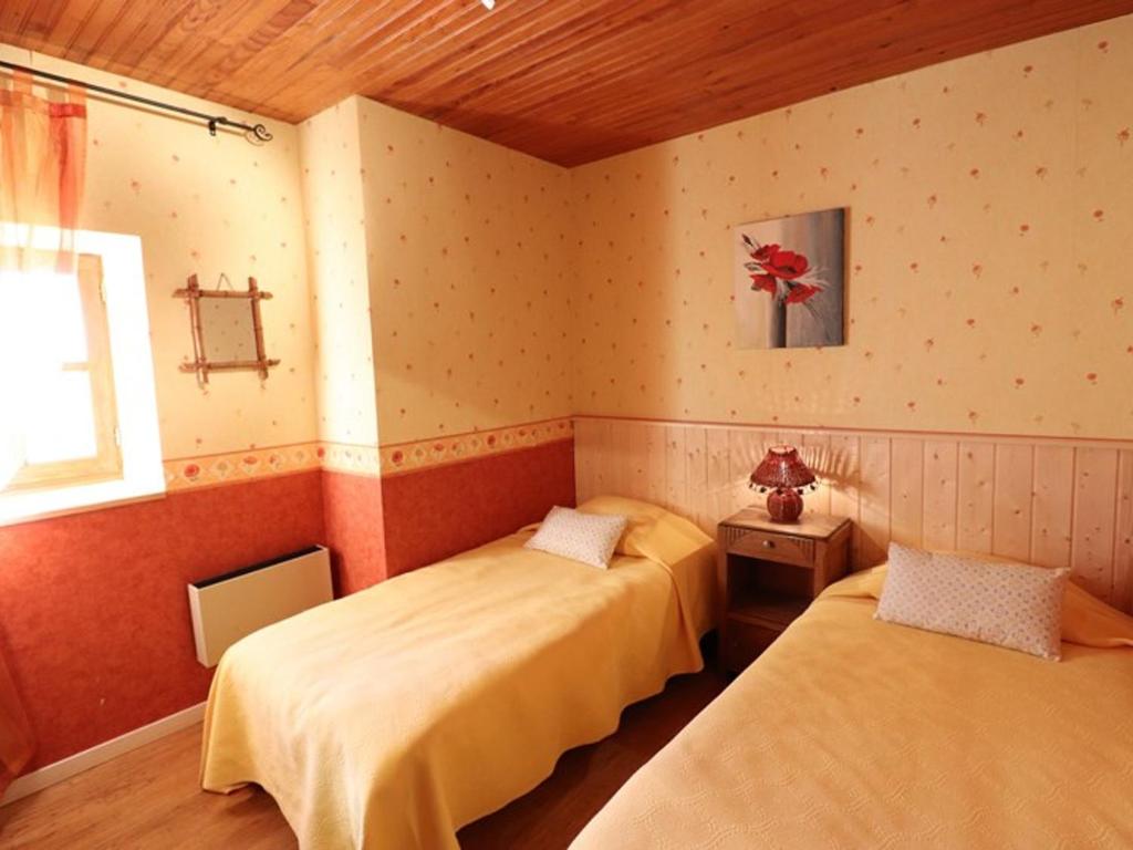 a bedroom with two beds and a window in it at Gîte Sansac-Veinazès, 3 pièces, 4 personnes - FR-1-742-114 