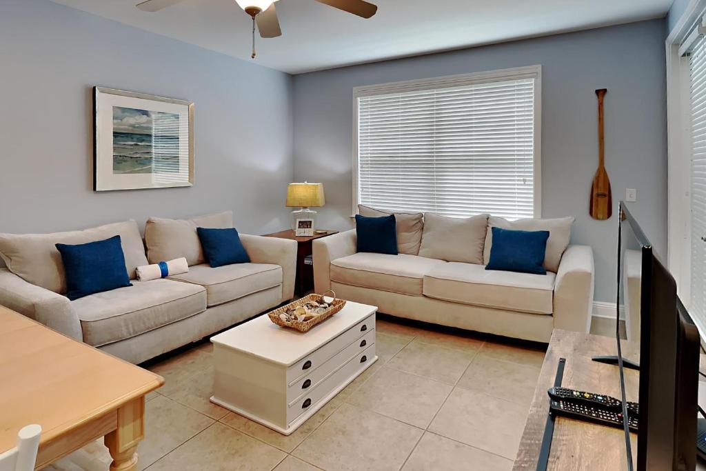 a living room with two couches and a tv at The Village 514 in Blue Mountain Beach
