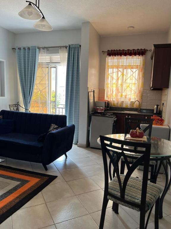 Una sala de estar con un sofá azul y una mesa. en Vee's place, en Buwate
