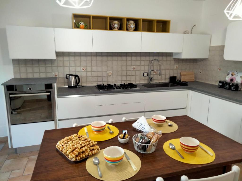 a kitchen with a wooden table with yellow dishes on it at La Castellina 23 in Sulmona