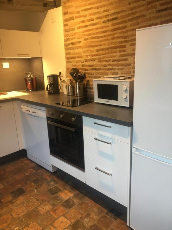 a kitchen with a stove and a microwave at Studio cosy atypique in La Ferté-Bernard
