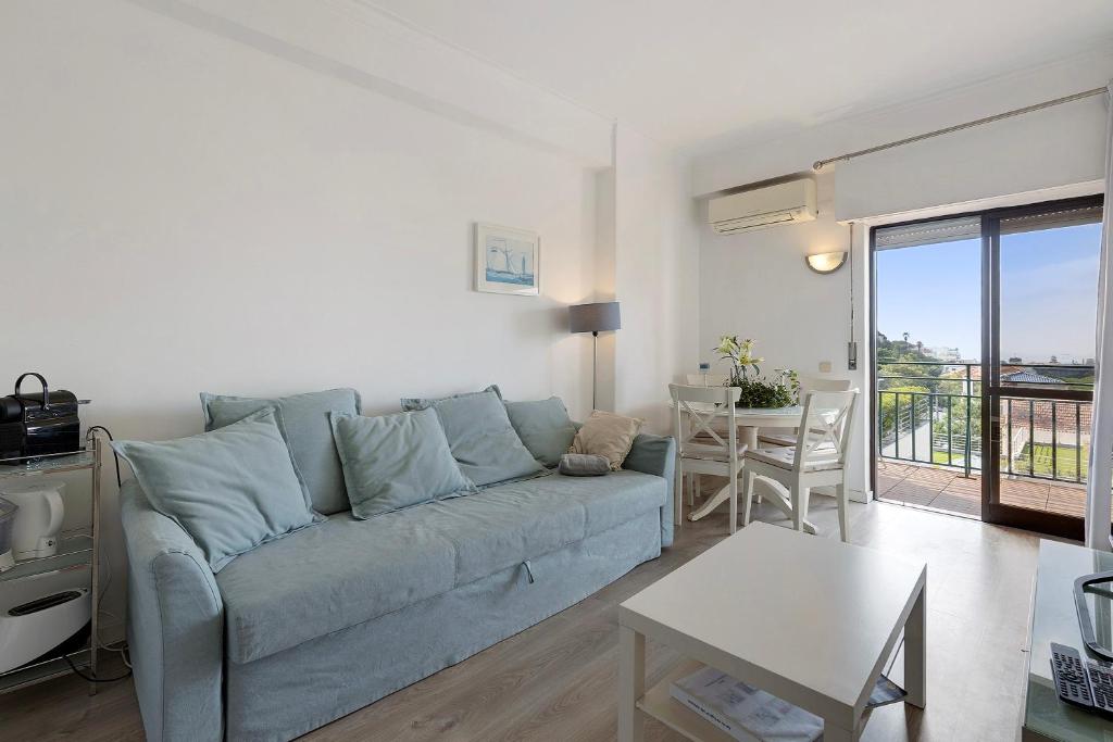 sala de estar con sofá azul y mesa en Sea View Estoril, en Estoril