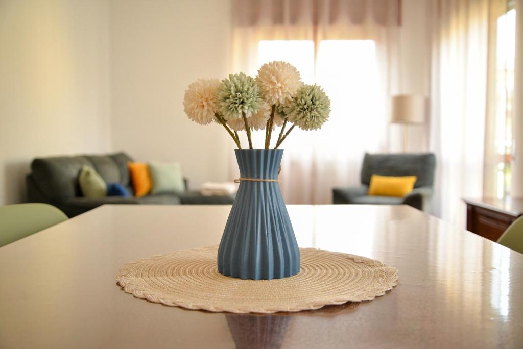 un jarrón azul con flores sentado en una mesa en "La Villa dei Nonni" appartamento, en Bérgamo