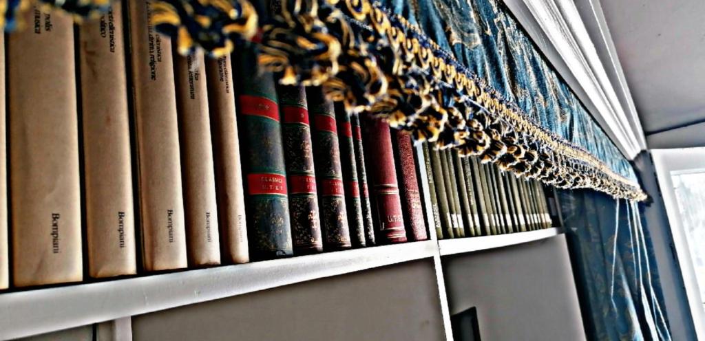 a row of books on a book shelf at Casa Perni in Buccheri