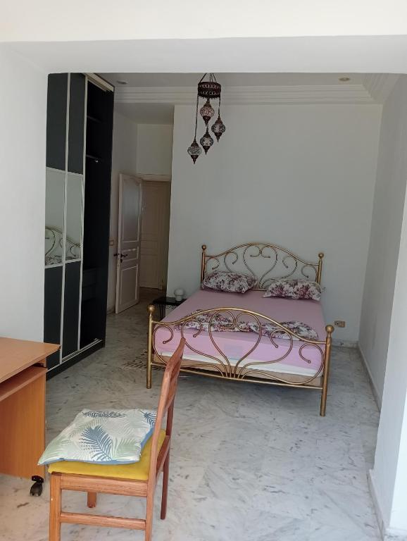 a bedroom with a pink bed and a chair at Mia casa in La Goulette
