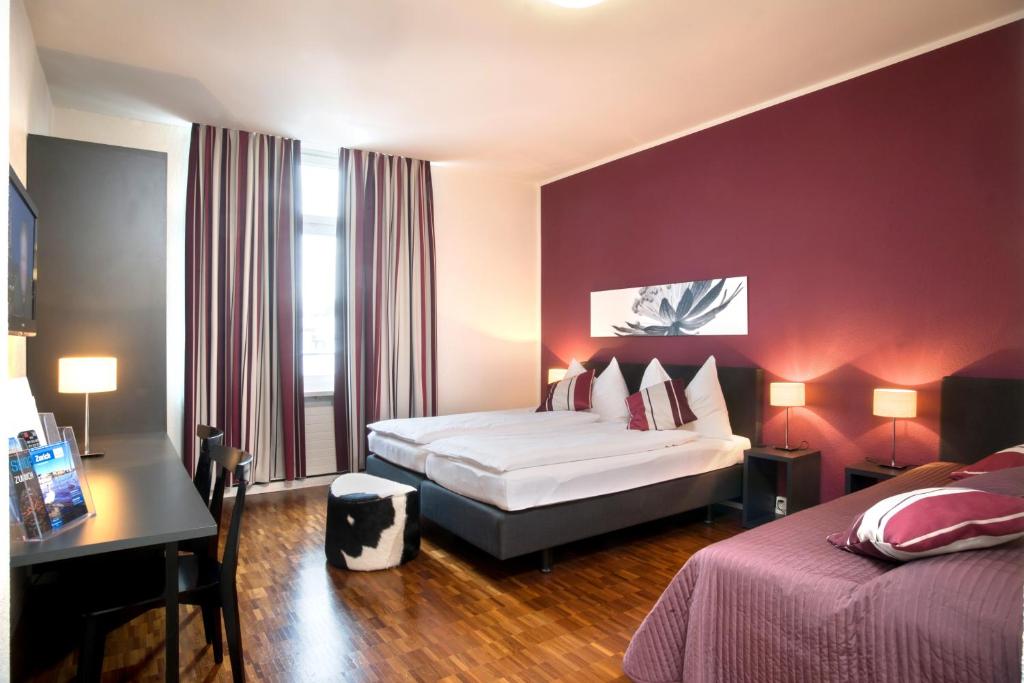 Habitación de hotel con cama y escritorio con ordenador portátil en Hotel Hottingen en Zúrich