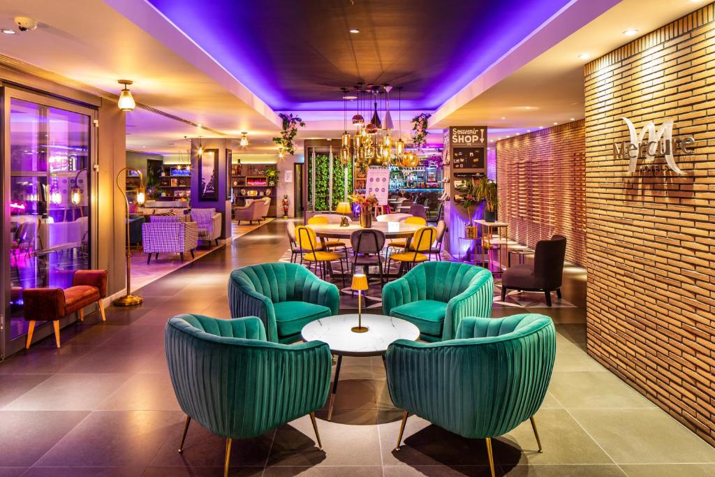 un restaurant avec des chaises et des tables vertes dans une pièce dans l'établissement Mercure London Bridge, à Londres