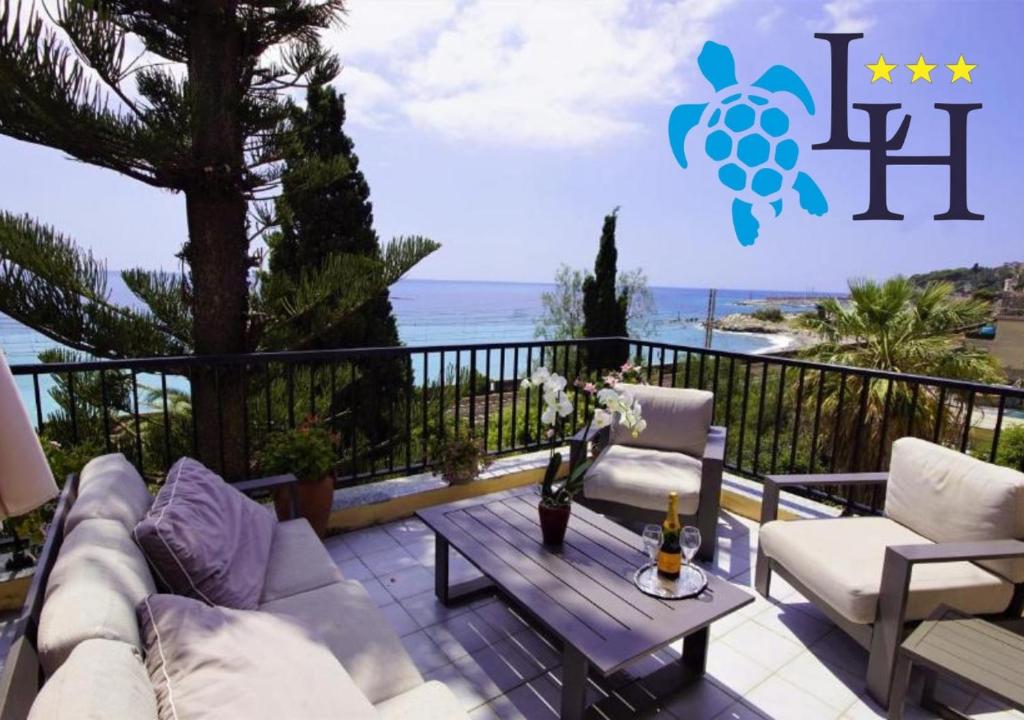 a patio with a table and chairs and the ocean at Hotel Lora in Bordighera