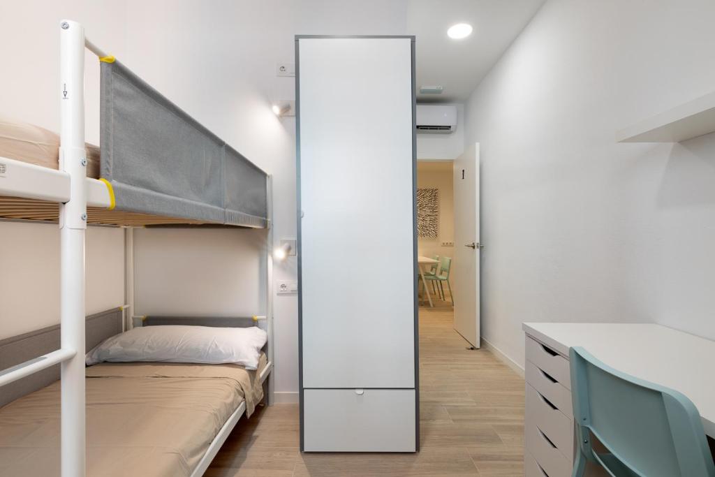 een slaapkamer met een stapelbed en een spiegel bij LaResiBCN minimum 30 nights in Barcelona