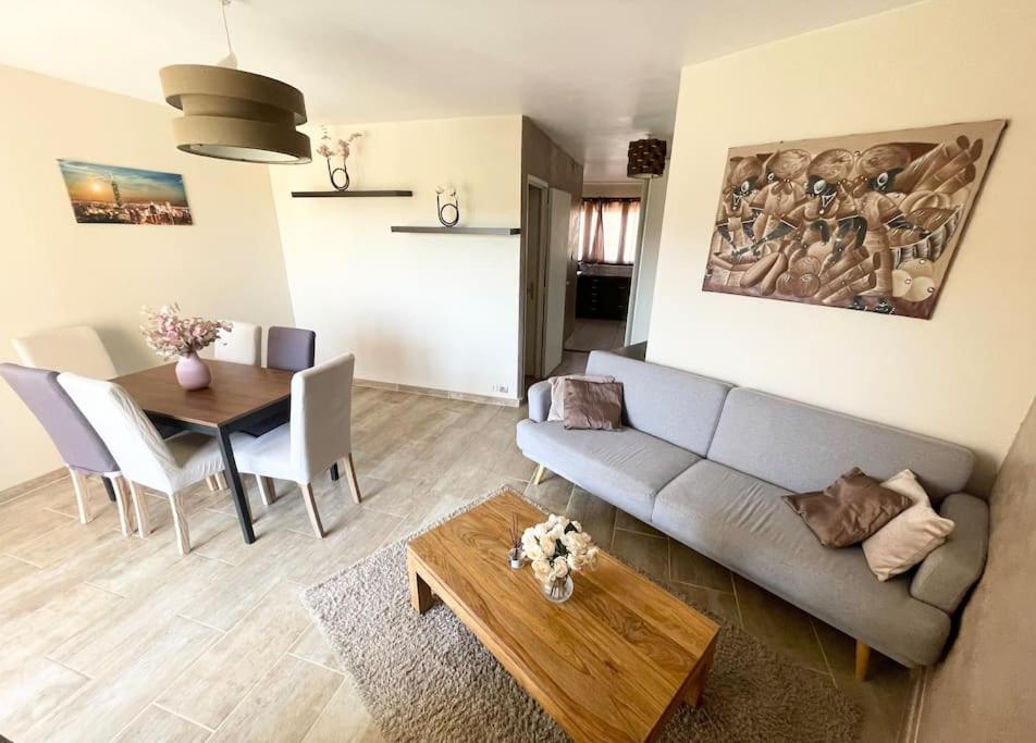 uma sala de estar com um sofá e uma mesa em Grand appartement idéalement situé em Villeurbanne