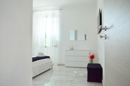 um quarto branco com uma cama e uma cómoda em “La Casa di Margi” em Nápoles