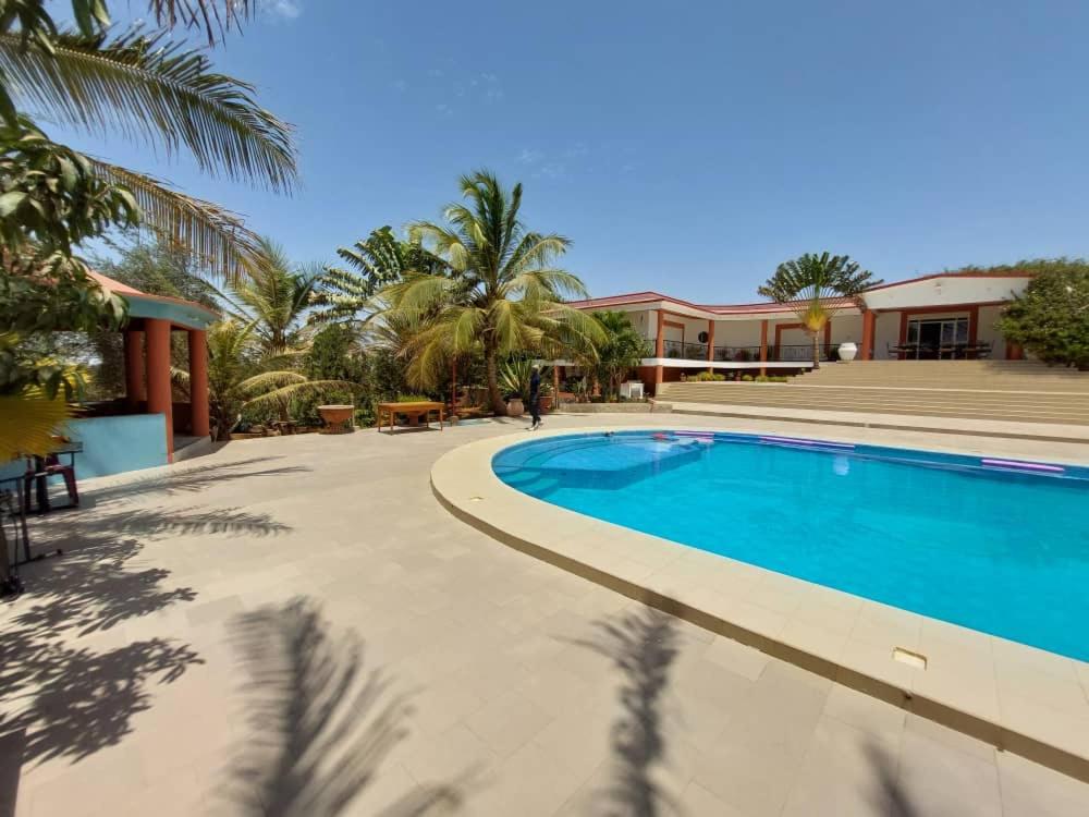 uma piscina em frente a uma casa com palmeiras em RESIDENCE LE BELIER 