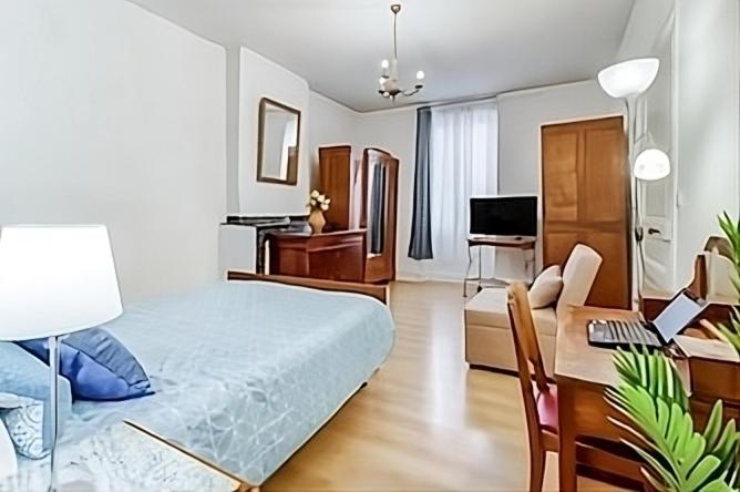 een slaapkamer met een bed en een bureau met een laptop bij Tarbes Marcadieu T2 RDC et 1er étage Centre ville et nature in Tarbes