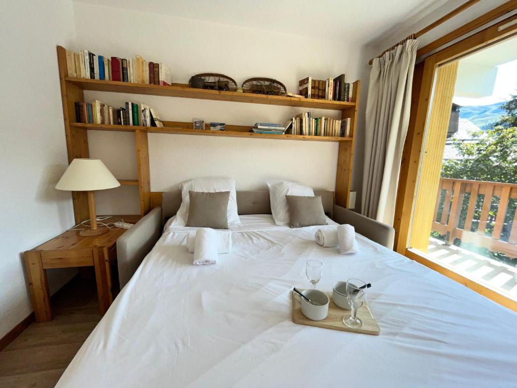 a bedroom with a large white bed with a window at Appartement Méribel, 3 pièces, 6 personnes - FR-1-688-36 in Méribel