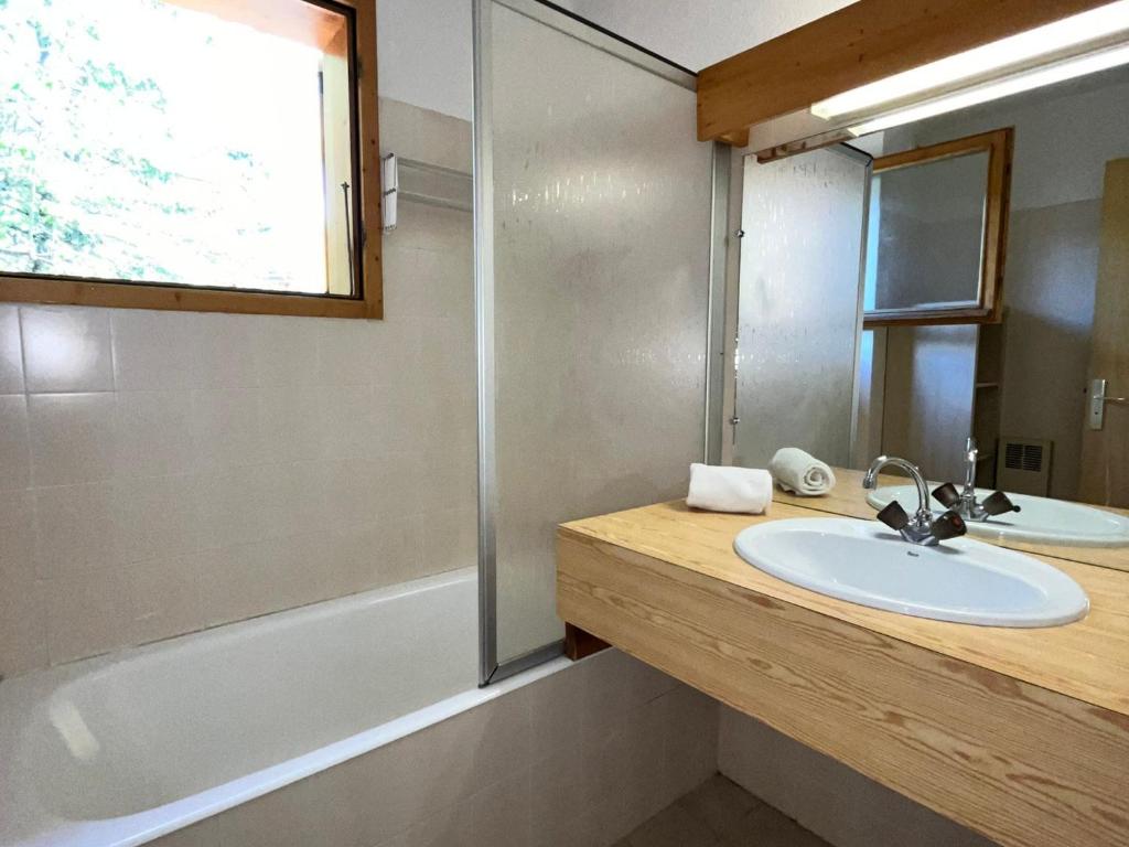 a bathroom with a sink and a tub and a mirror at Appartement Méribel, 3 pièces, 6 personnes - FR-1-688-36 in Méribel