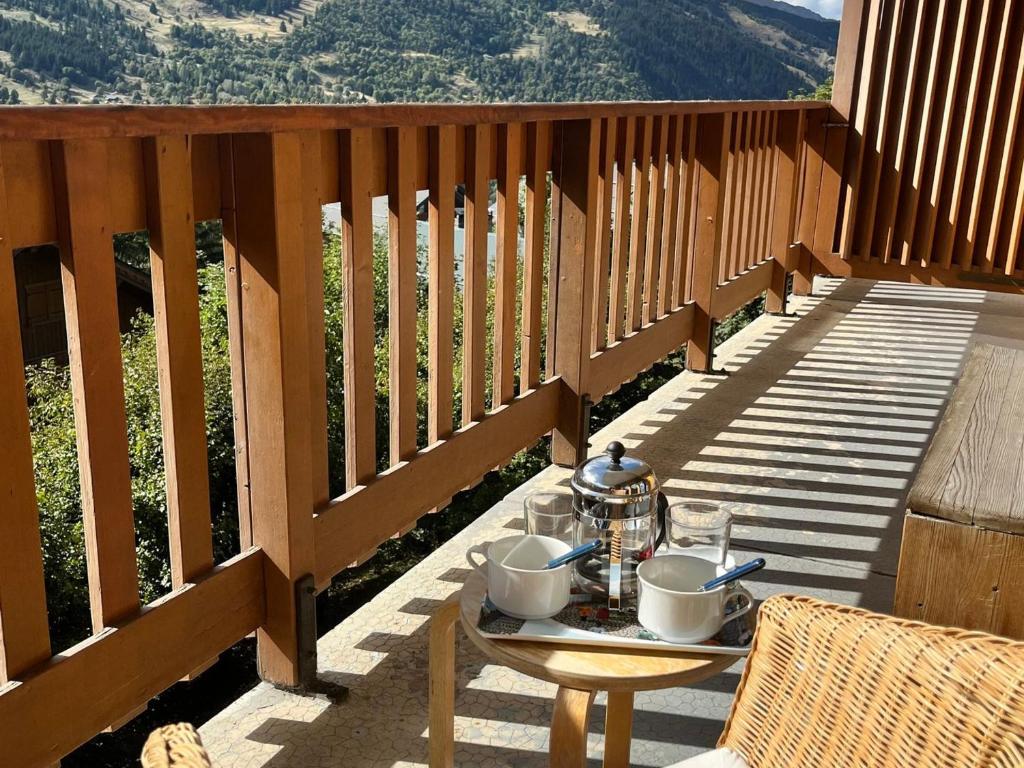 a table on a wooden deck with a tea set on it at Appartement Méribel, 3 pièces, 6 personnes - FR-1-688-36 in Méribel
