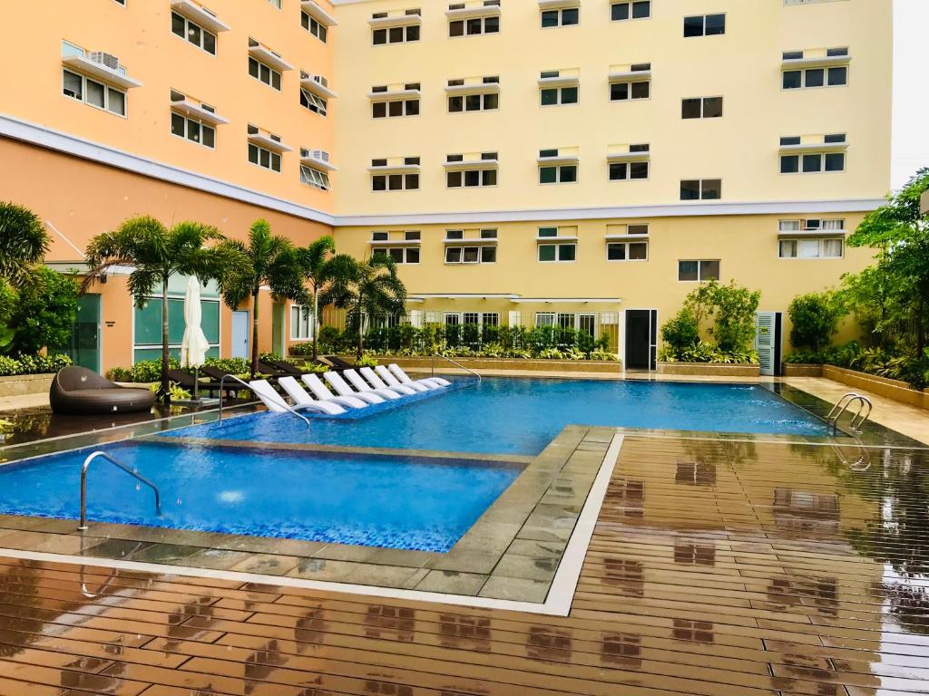 a swimming pool in front of a building at JFam Suites - Studio and 1Bedroom Units! in Biñan