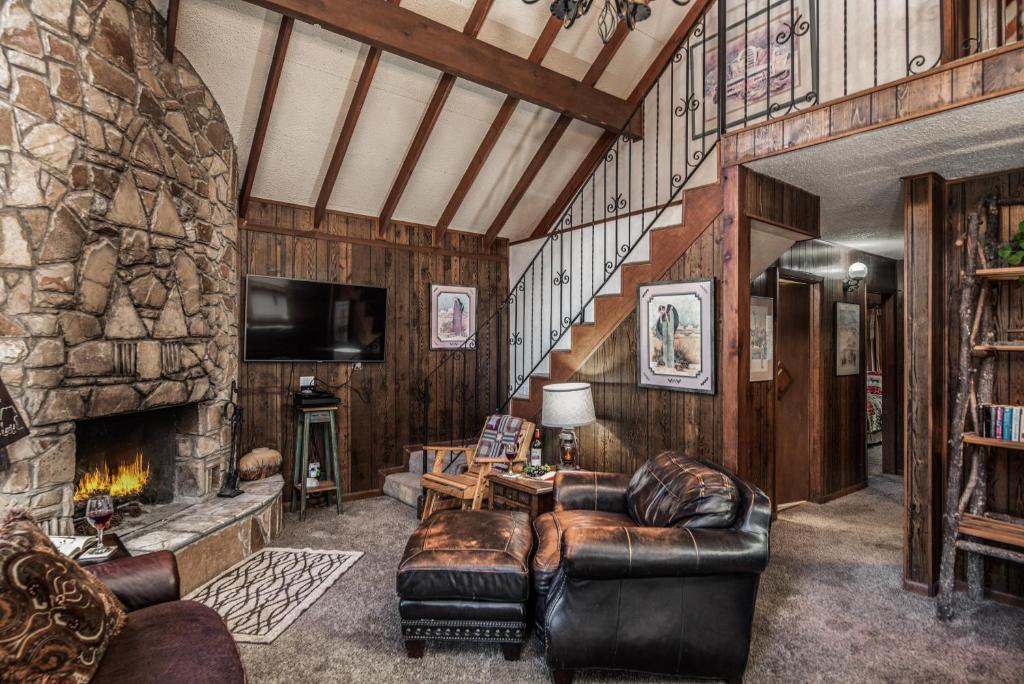 uma sala de estar com sofás e uma lareira de pedra em Knott Inn em Ruidoso