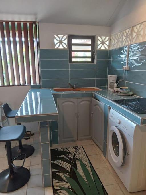 a kitchen with a sink and a washing machine at Studio proche aéroport 2perswifi in Matoury