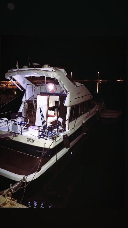 a white boat sitting in the water at night at Thalassa in Katakolo