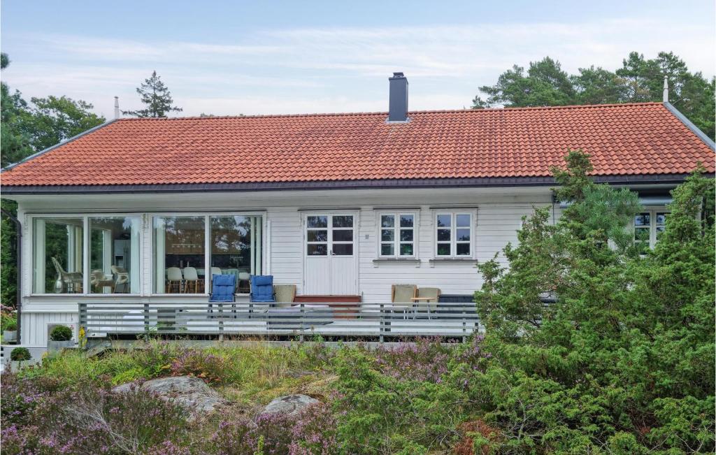a small white house with an orange roof at Cozy Home In Grimstad With House Sea View in Grimstad