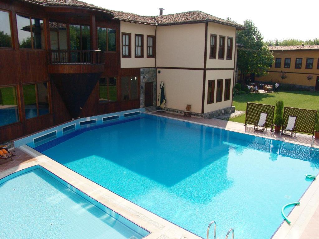 a large swimming pool in front of a house at Otantik Hotel & Spa in Bursa