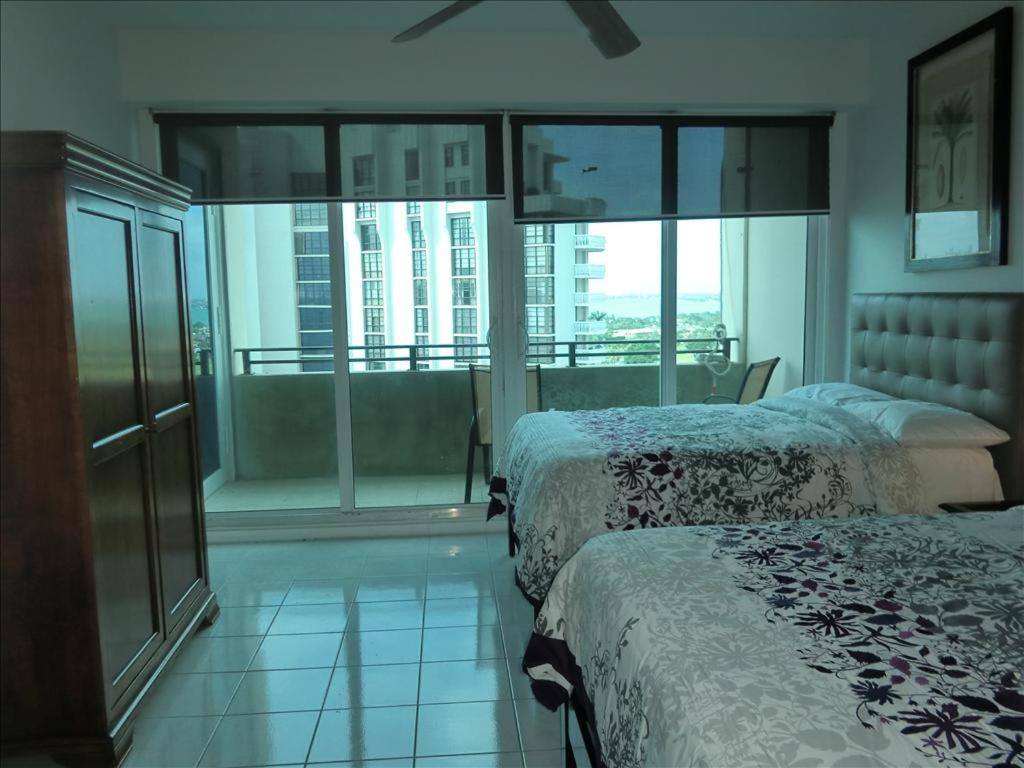Habitación de hotel con 2 camas y balcón en Spacious One bedroom Bay View Penthouse, en Miami Beach