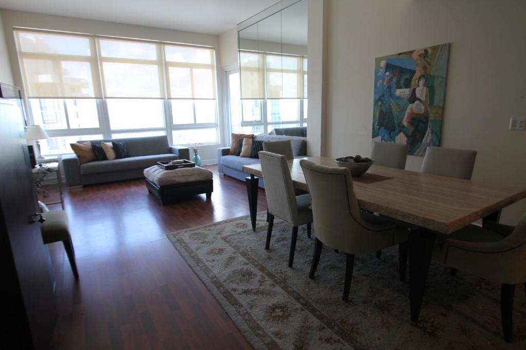 sala de estar con mesa, sillas y sofá en 2 BD Penthouse with Balcony, en Miami Beach