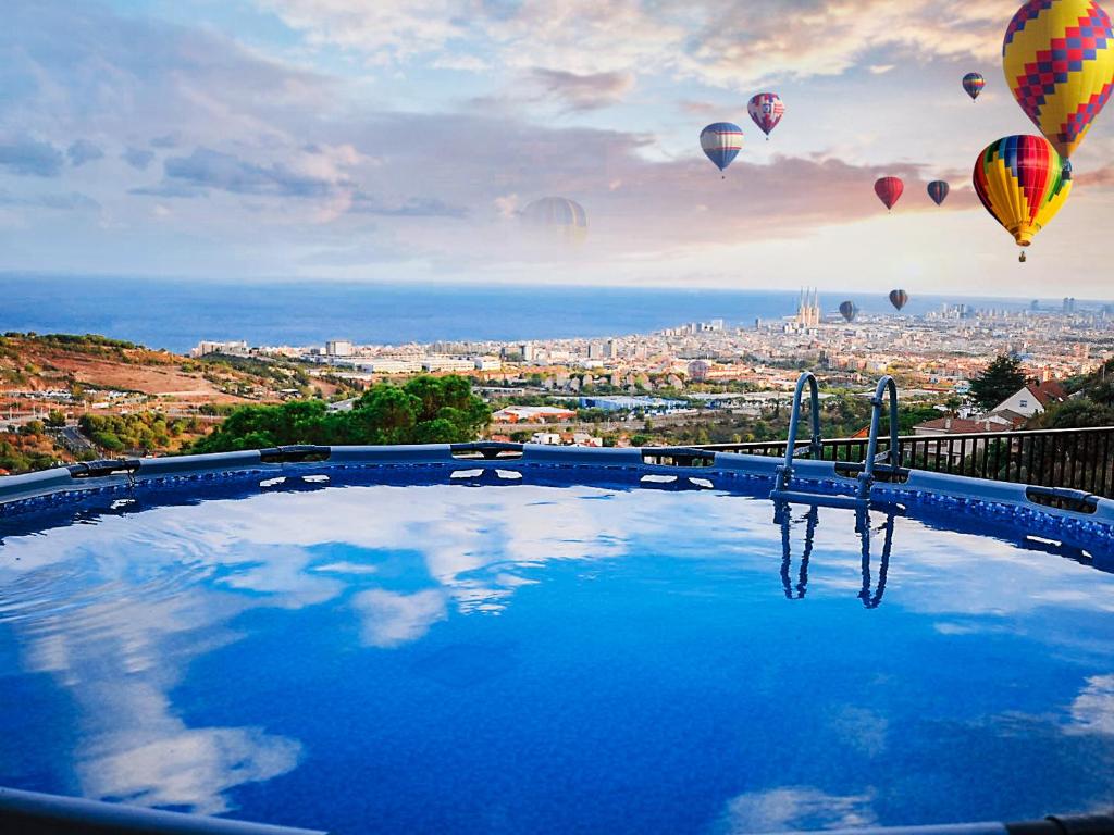 una gran piscina con globos de aire caliente en el cielo en A+View Private Terrace Private Pool Family Fun, en Badalona