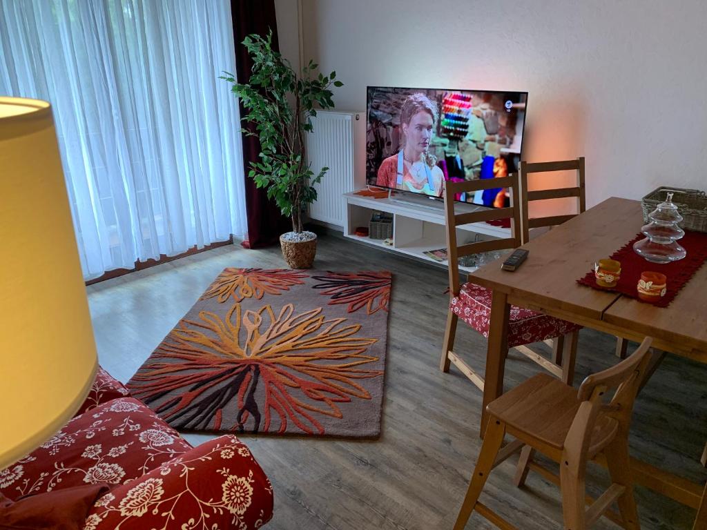 ein Wohnzimmer mit einem Tisch und einem TV in der Unterkunft Wohnen im Herrenwäldchen in Brombachtal