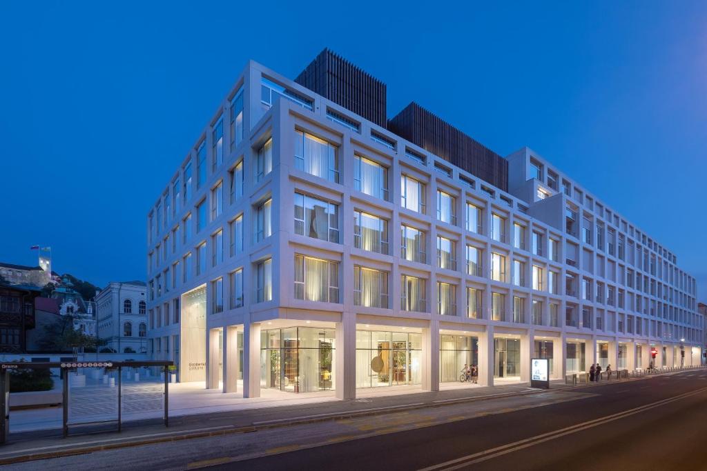 a large white building on a street at night at Occidental Ljubljana in Ljubljana