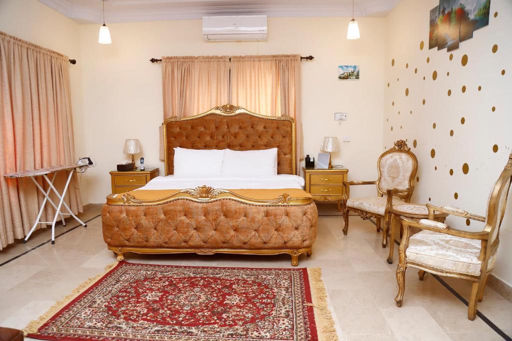 a bedroom with a large bed and a chair at Waypoint Hotel in Karachi
