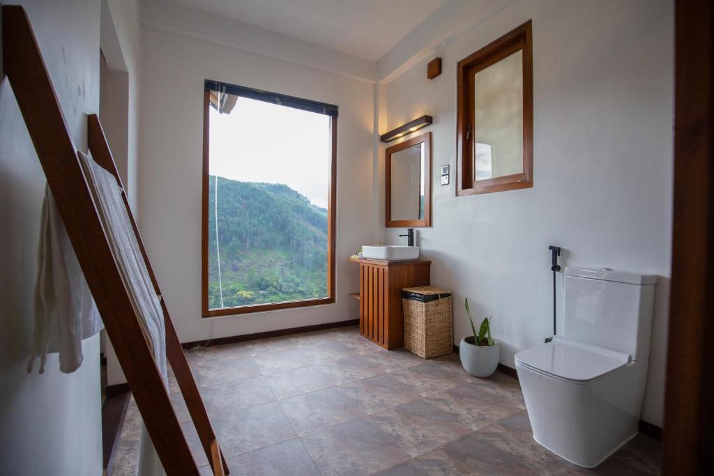 łazienka z toaletą i oknem w obiekcie Dowa Elegance Resort w mieście Ella