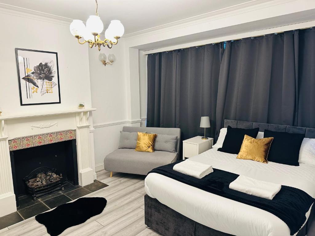 um quarto com uma cama king-size e uma lareira em Lovely 4 Bedroom House with 2 Bathroom, Garden and Private Parking em Thornton Heath