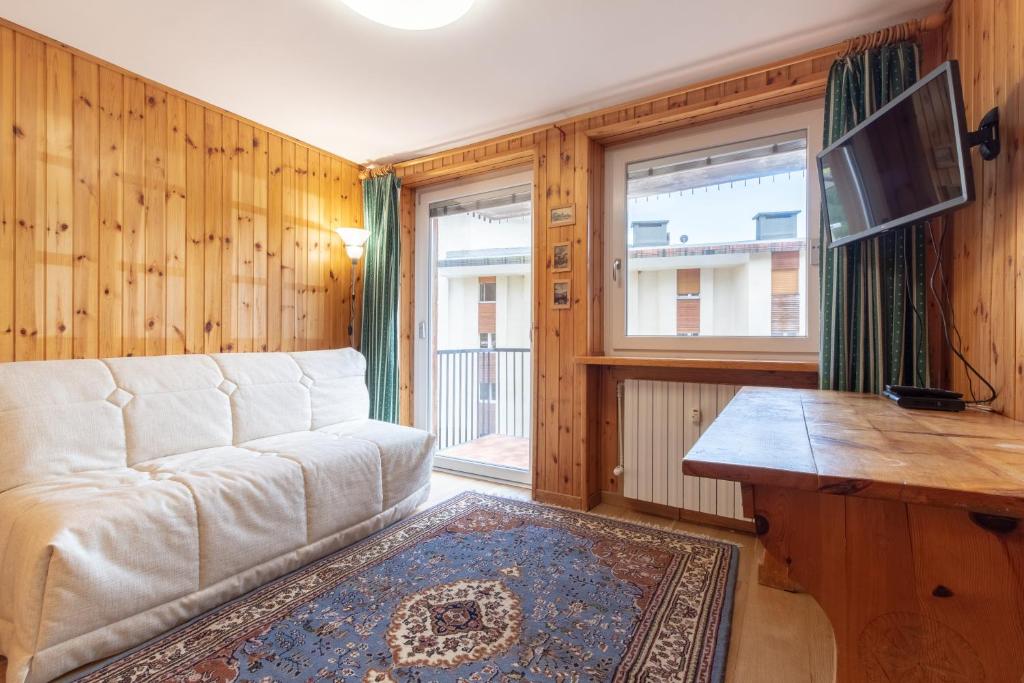 a living room with a couch and a tv and a window at Monolocale ristrutturato in centro paese con wifi AS19 in Breuil-Cervinia