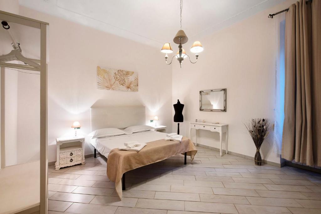 um quarto branco com uma cama e um espelho em House Corso Dogali Aquarium em Gênova
