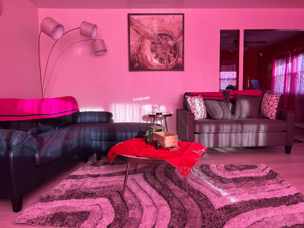 Sala de estar de color rosa con sofá y mesa en Have fun enter 5 bedroom cape cod Bungalow., en Des Plaines