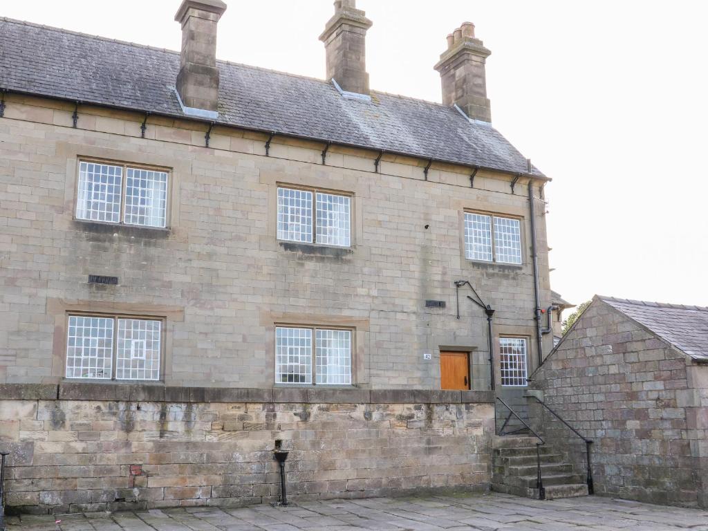 an old brick building with a orange door at The Cottage in Belper