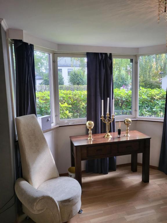 a room with a desk and a chair and windows at TT Mansion in Oslo