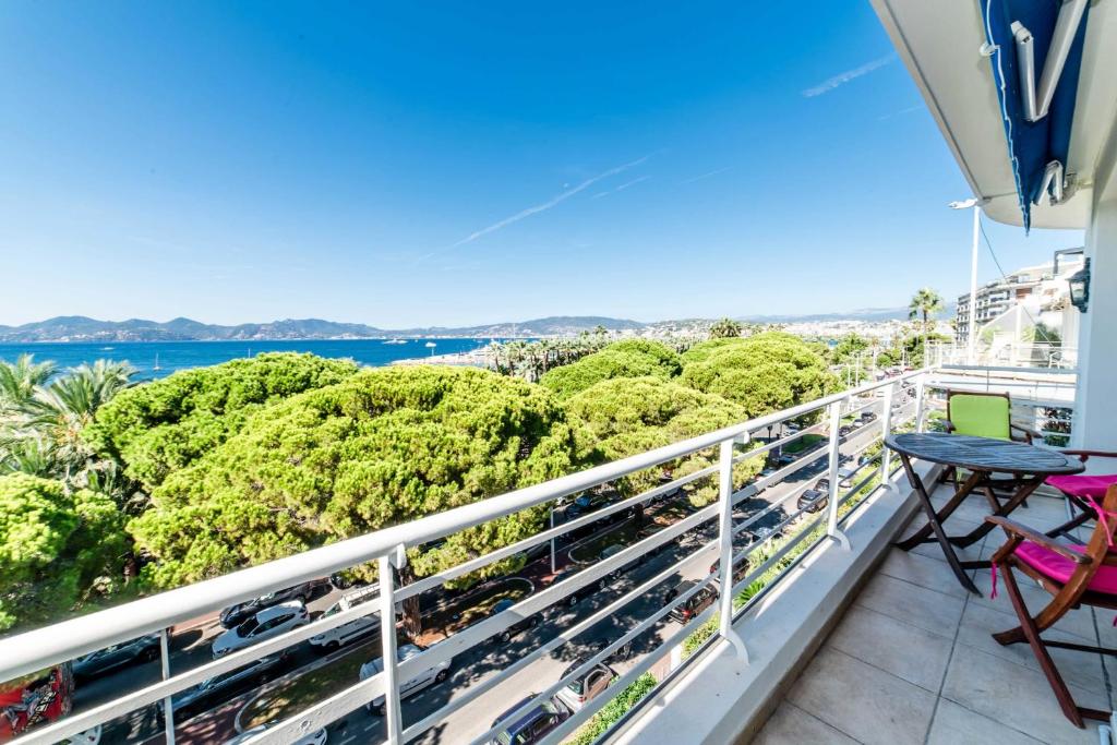 uma varanda com vista para o mar e para as árvores em Residence Les Voiles Blanches - Postcard view on the Croisette em Cannes