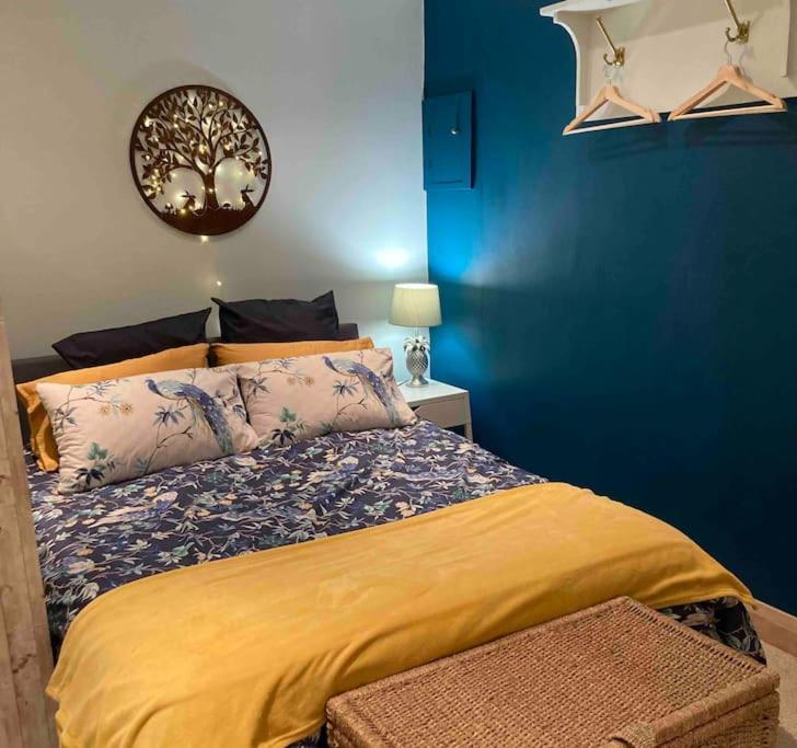 um quarto com uma cama com uma parede azul em The Hideaway at Peacock Farm em Bottesford