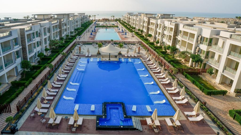 SeaVille Beach Hotel by Elite Hotels & Resorts في العين السخنة: اطلالة جوية على مجمع شقق مع مسبح