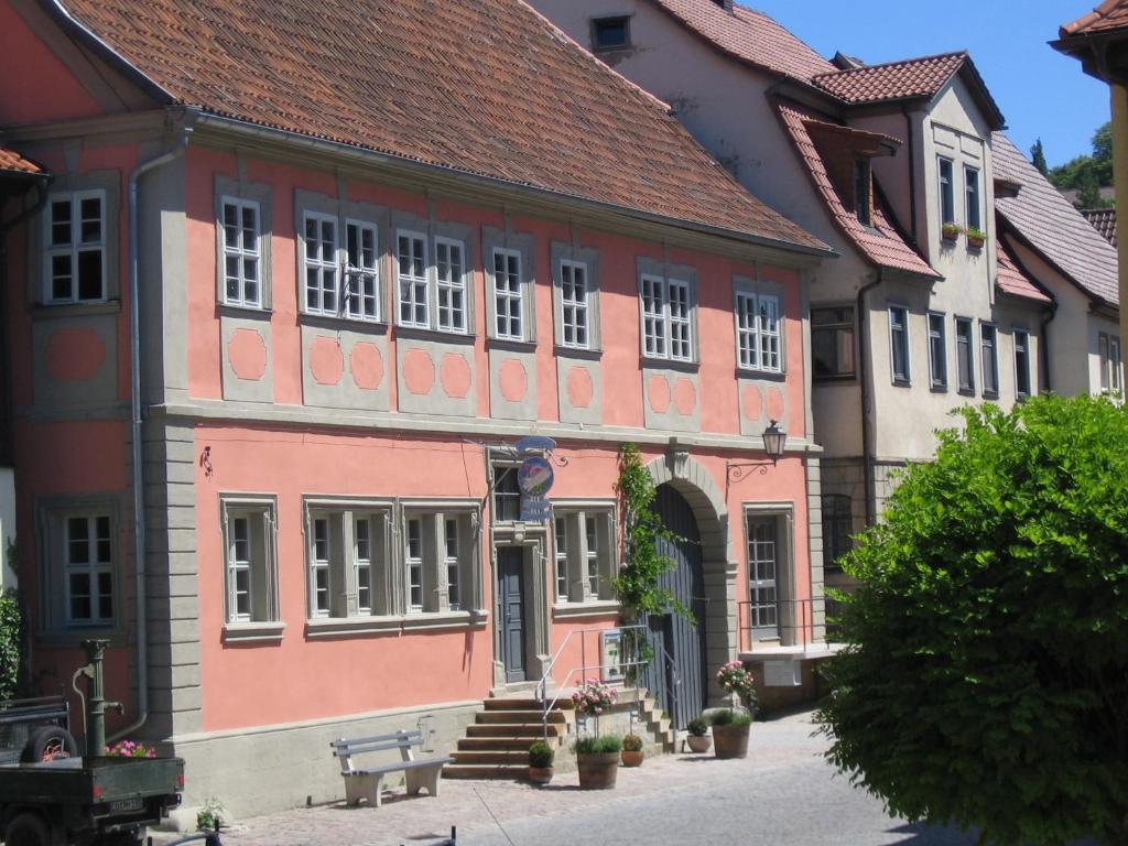 ein rosafarbenes Gebäude mit rotem Dach in der Unterkunft Pörtnerhof Seßlach in Seßlach