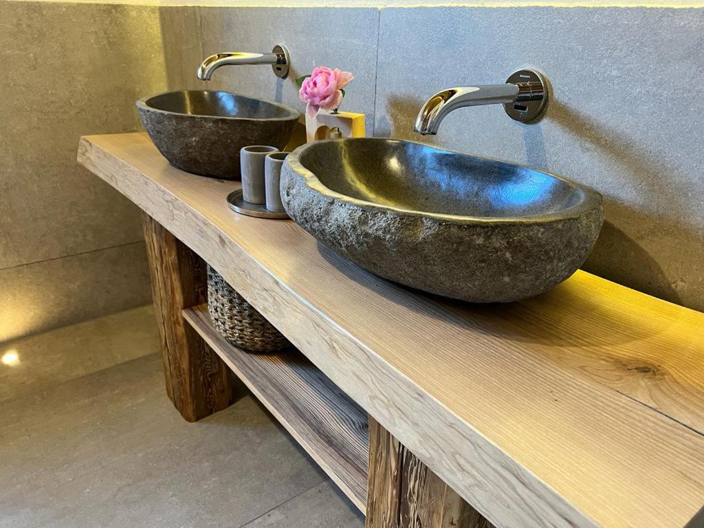 2 umywalki na drewnianym blacie w łazience w obiekcie Alpflower w mieście Halblech
